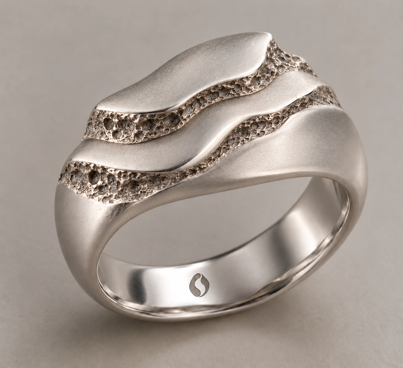 Concept de la bague Strate, large · reliefs superposés. Logo Ondralith gravé à l’intérieur.
